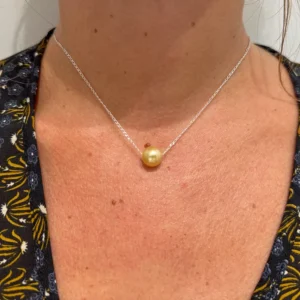 Collier à chaîne avec une perle dorée des mers du Sud porté au cou