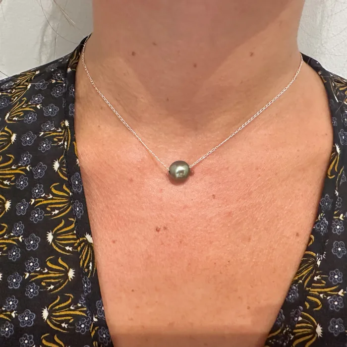 Chain necklace with a dark Tahitian pearl worn around the neck
