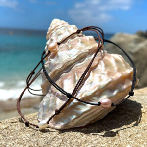 Three adjustable necklaces with oval freshwater pearls displayed on mother-of-pearl