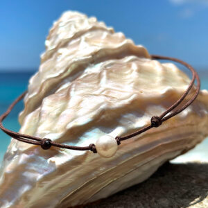Adjustable necklace with a semi-round pink freshwater pearl on a brown cord