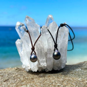 Deux colliers ajustables avec perles de Tahiti baroques cerclées présentés sur un cristal