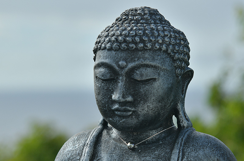 Collier chaîne en argent 925 avec une perle de culture de Tahiti présenté sur une statue de Bouddha face à la mer
