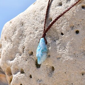 Braided kangaroo leather necklace with a Larimar pendant displayed on a rock