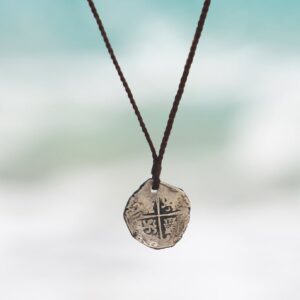 Collier en cuir de kangourou tressé avec une ancienne monnaie de 8 réaux en argent présentée en pendentif