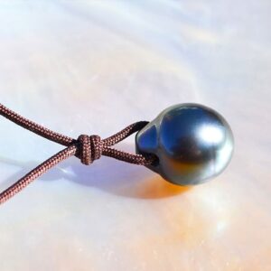 Detail of the knot and 13 mm drop-shaped Tahitian cultured pearl on the pendant necklace displayed on mother-of-pearl