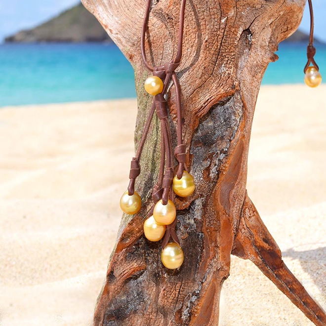 Cluster of seven South Sea cultured pearls on the adjustable necklace hanging from driftwood facing the sea