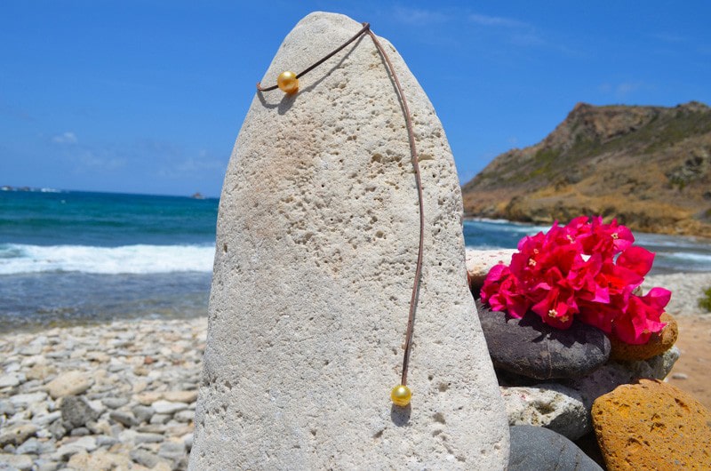 Collier ajustable en cuir déployé avec sa perle principale et sa perle d’ajustement dorées des mers du Sud