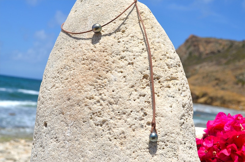 Vue d’ensemble du collier ras du cou en cuir avec une perle de Tahiti de 11 mm et sa perle d’ajustement à la plage