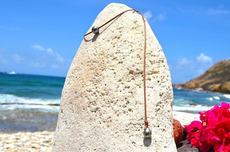Full view of the leather choker with a 12 mm Tahitian pearl and its adjustment pearl at the beach