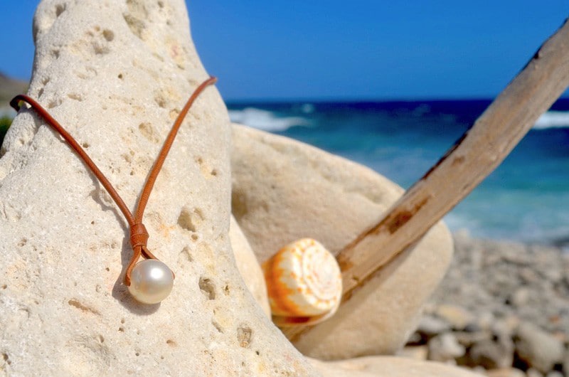 Close view of the 12 mm baroque South Sea pearl and brown leather setting of the pendant necklace