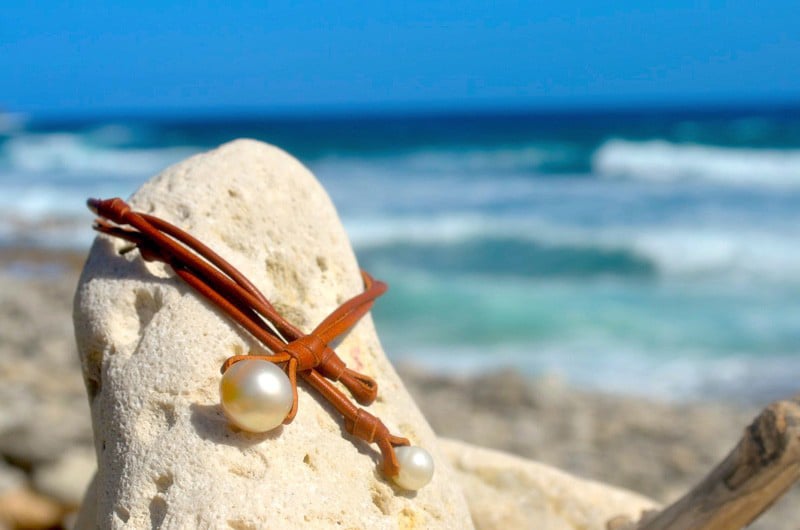 Close-up of the baroque South Sea main pearl and knot on the leather necklace facing the sea