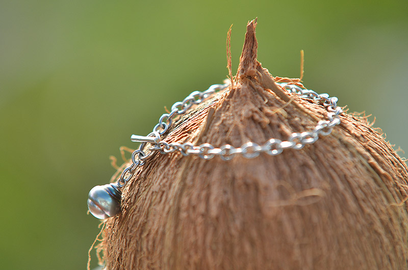 Bracelet chaîne en argent 925 avec une perle de Tahiti suspendu sur une coque de noix de coco