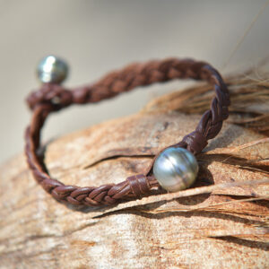Bracelet pour homme en cuir marron tressé à six fils avec perles de culture de Tahiti présenté sur du bois