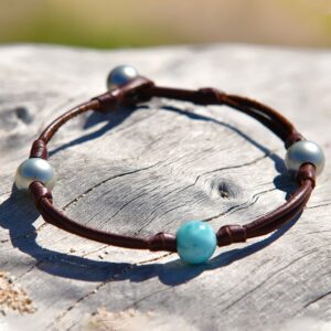 Bracelet ou chevillère en cuir marron avec Larimar et perles de culture de Tahiti présenté sur du bois flotté