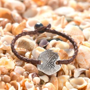 Bracelet en cuir marron tressé avec ancienne monnaie de 2 réaux en argent et perle de culture de Tahiti présenté sur des coquillages