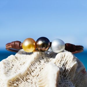 Bracelet en cuir marron avec trois perles de culture multicolores de 9,5 mm présenté sur une nacre