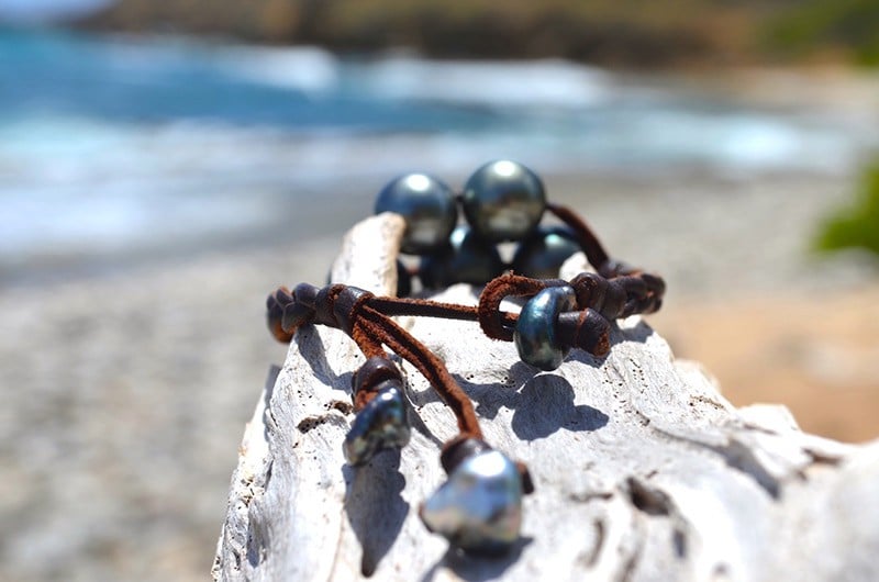 Autre vue du bracelet avec sept perles de Tahiti présenté sur du bois face à la mer
