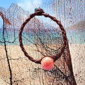 Vue d’ensemble du bracelet avec perles de corail et de Tahiti présenté sur un éventail de mer