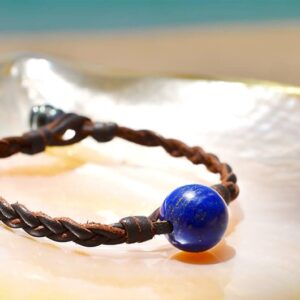 Bracelet tressé avec lapis-lazuli et perle de Tahiti présenté sur une nacre