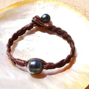 Bracelet tressé avec une perle de Tahiti cerclée présenté sur une nacre