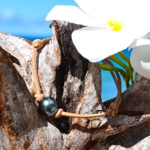 Adjustable brown leather bracelet with a 10.5 mm semi-round Tahitian cultured pearl displayed on wood with a white flower