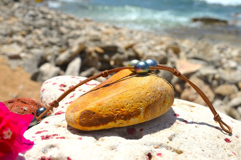 Vue complète du bracelet à deux rangs avec trois perles semi-baroques de Tahiti présenté autour d’un coquillage