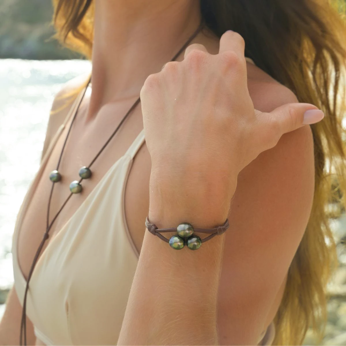 Bracelet en cuir à deux rangs avec trois perles baroques de Tahiti porté au poignet en vue rapprochée