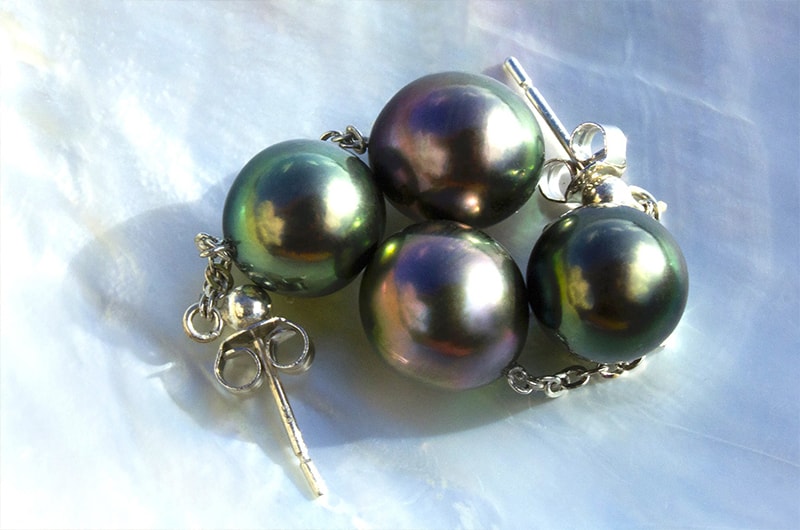 Close-up of the four Tahitian pearls and sterling silver earring settings on mother-of-pearl
