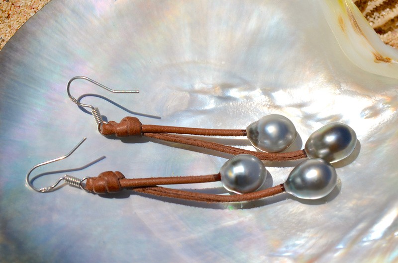 Leather earrings with four Tahitian pearls displayed on mother-of-pearl