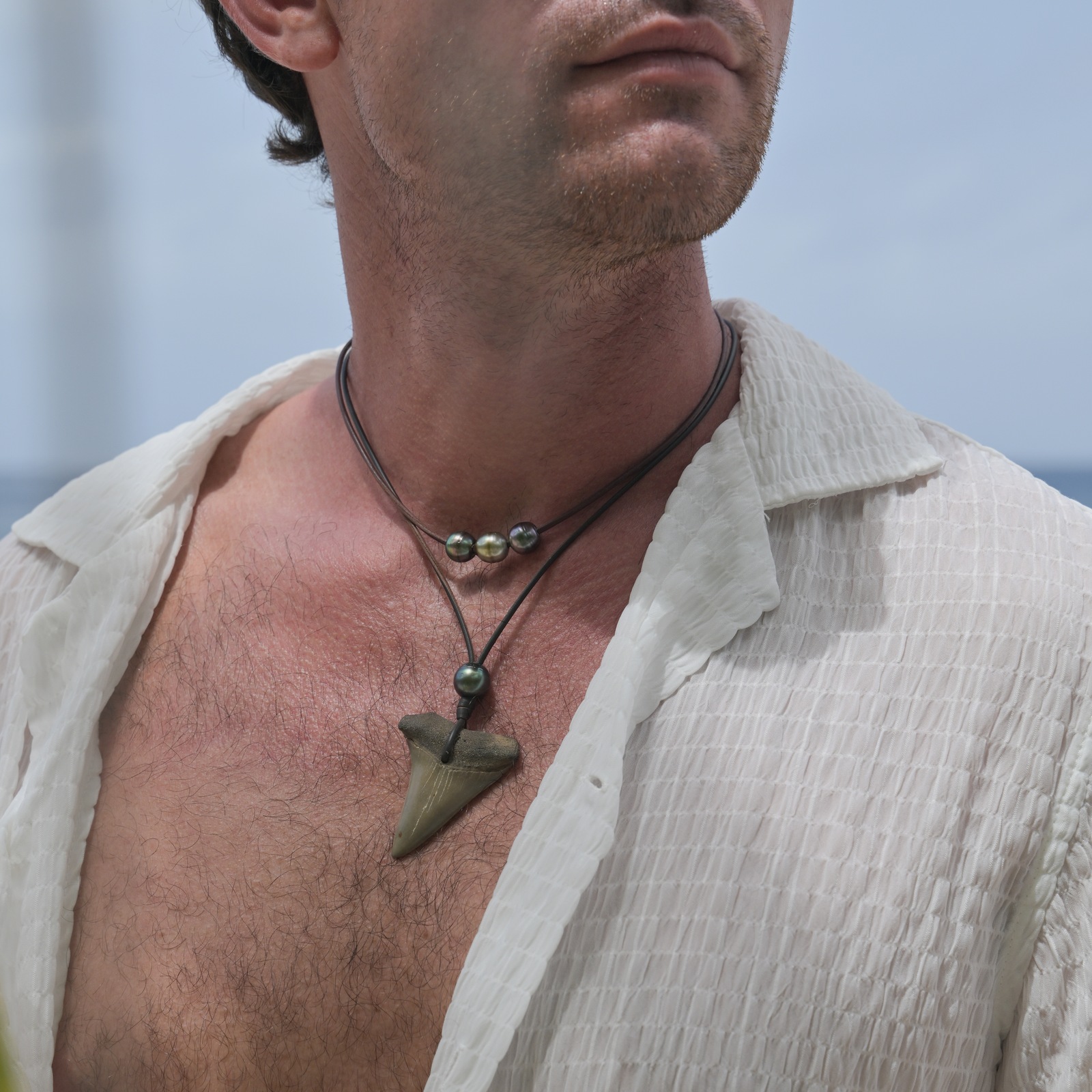 Ras du cou en cuir et trio de perles de Tahiti, vue portée en situation, cadrage carré autour du collier.