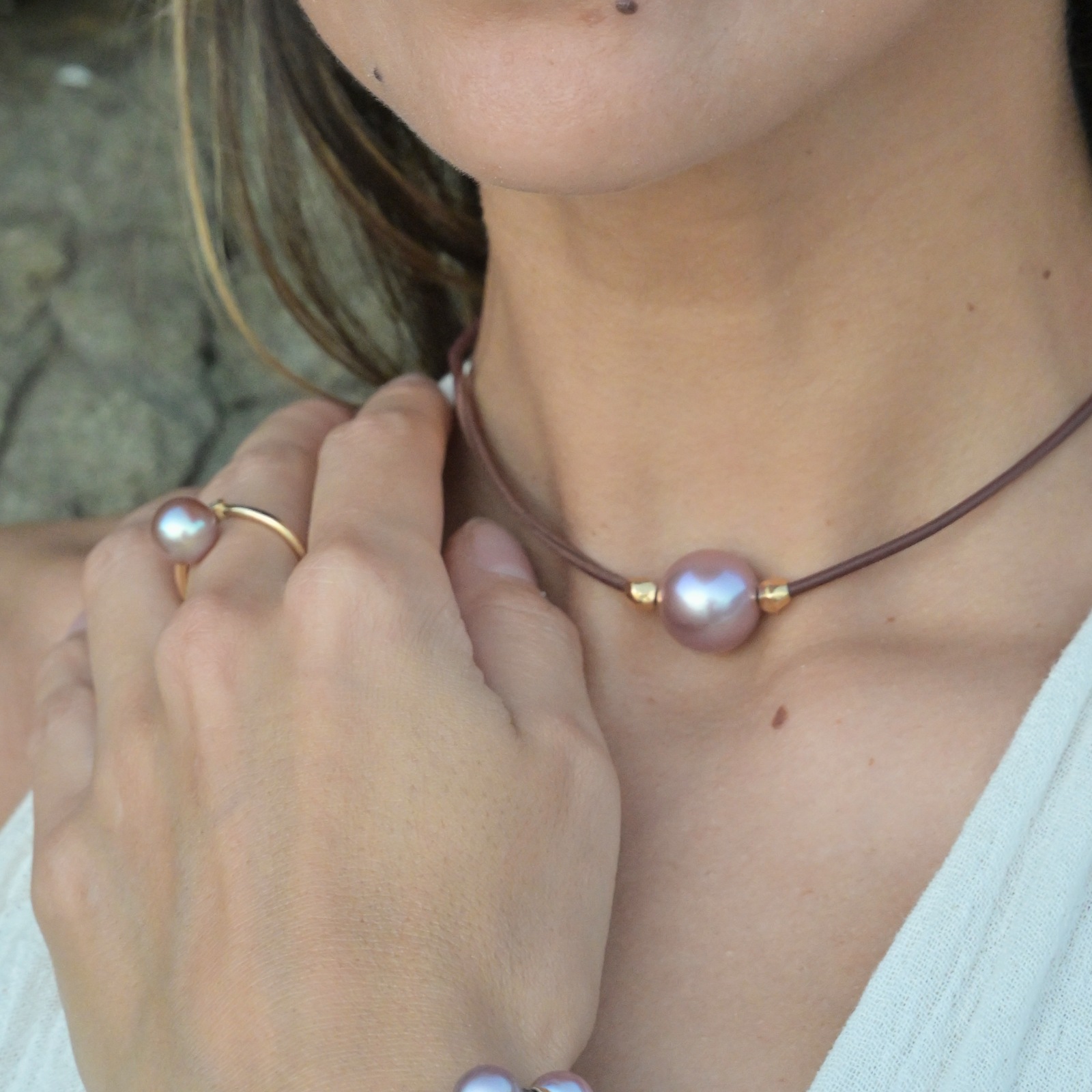Ras du cou en cuir, perle rose et billes en plaqué or, au cou.