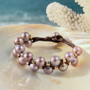 Bracelet double rang, perles roses et tubes martelés, sur un coquillage.