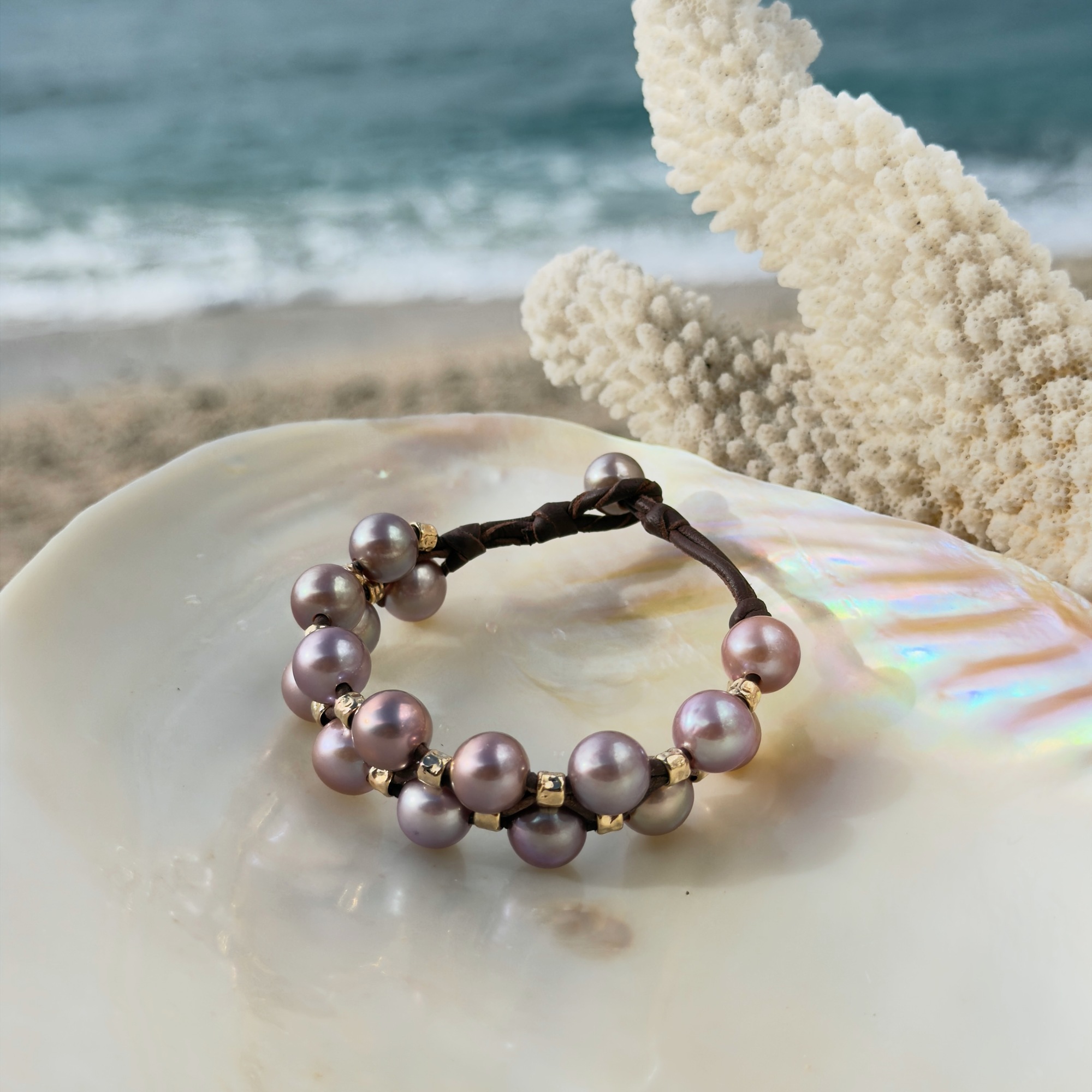 Double-row bracelet with pink pearls and hammered tubes, on a shell.