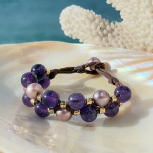 Bracelet double rang, perles roses et améthystes, sur un coquillage.