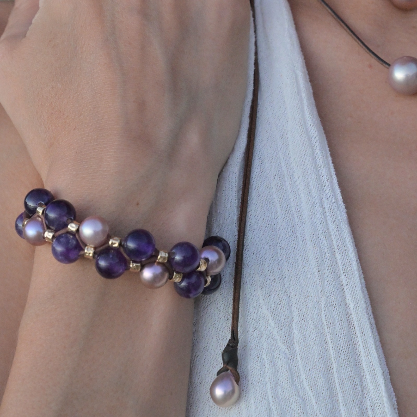 Bracelet double rang, perles roses et améthystes, au poignet.