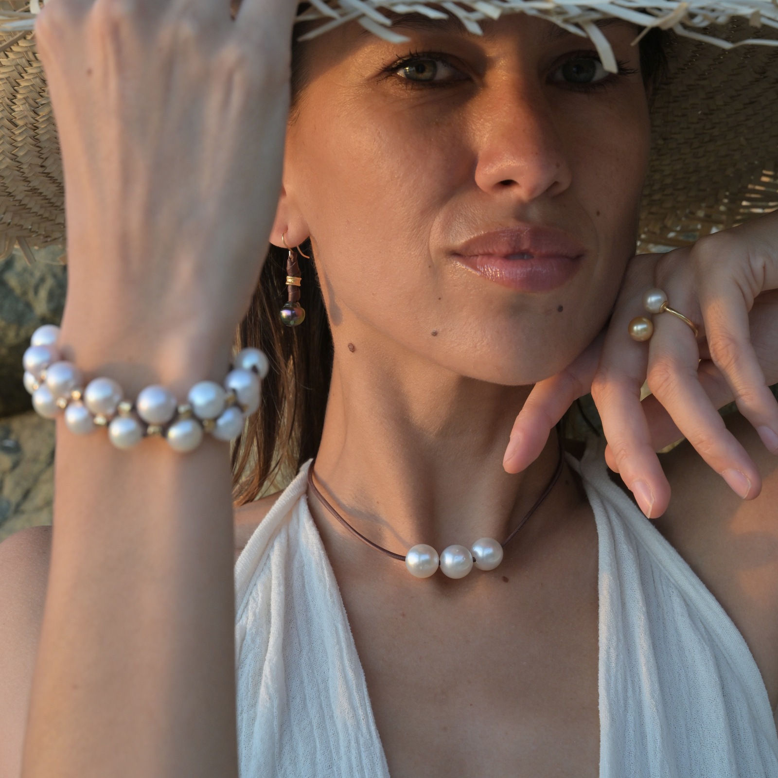 Double-row bracelet with white pearls and hammered tubes, worn in context, square view around the bracelet.