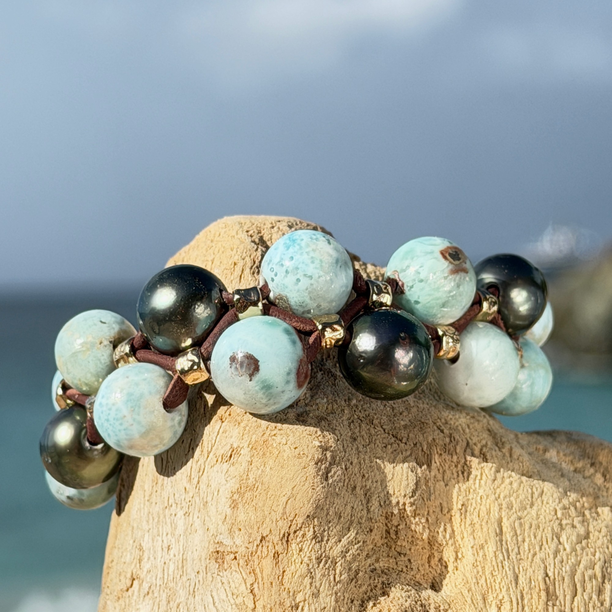 Bracelet double rang, Larimar et perles de Tahiti, sur du bois, détail.