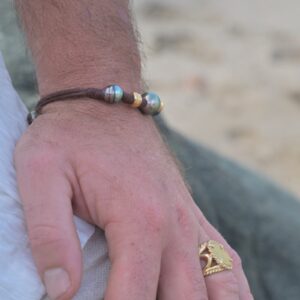Bracelet en cuir, trois perles baroques de Tahiti et rondelles dorées, vue portée en situation, cadrage carré autour du bracelet.