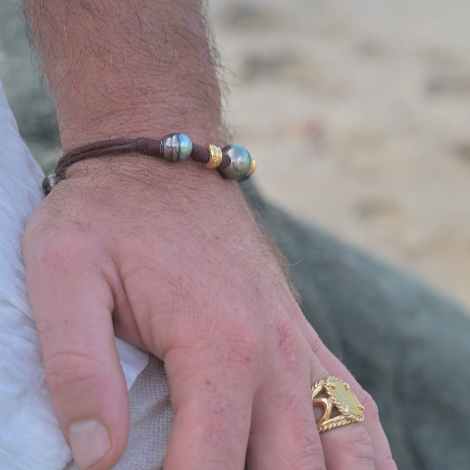 Bracelet en cuir, trois perles baroques de Tahiti et rondelles dorées, vue portée en situation, cadrage carré autour du bracelet.