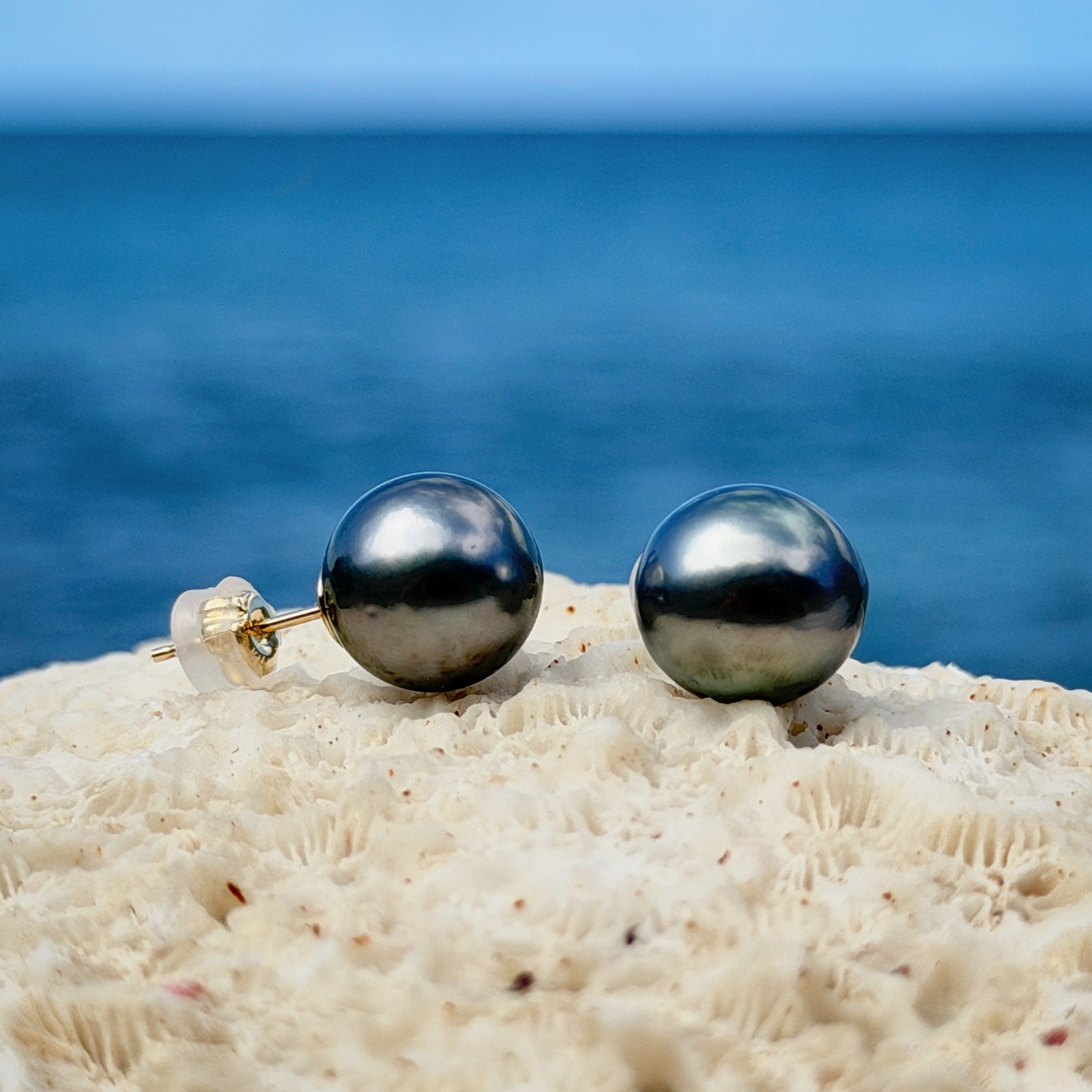 Clous en or et perles de Tahiti, sur un support de corail.