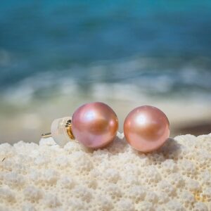 Clous en or et perles roses d’eau douce, perles roses, sur un support de corail.