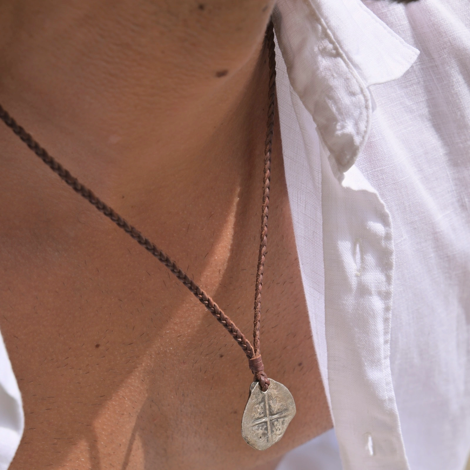 Braided Necklace with Pirate Coin worn at Shell Beach, close-up view of the jewelry.