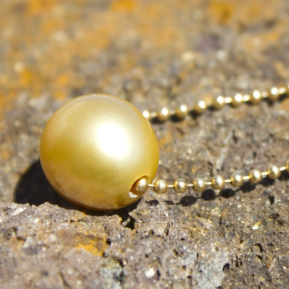 Close-up of the 12 mm golden South Sea cultured pearl and 14-karat gold chain on the necklace