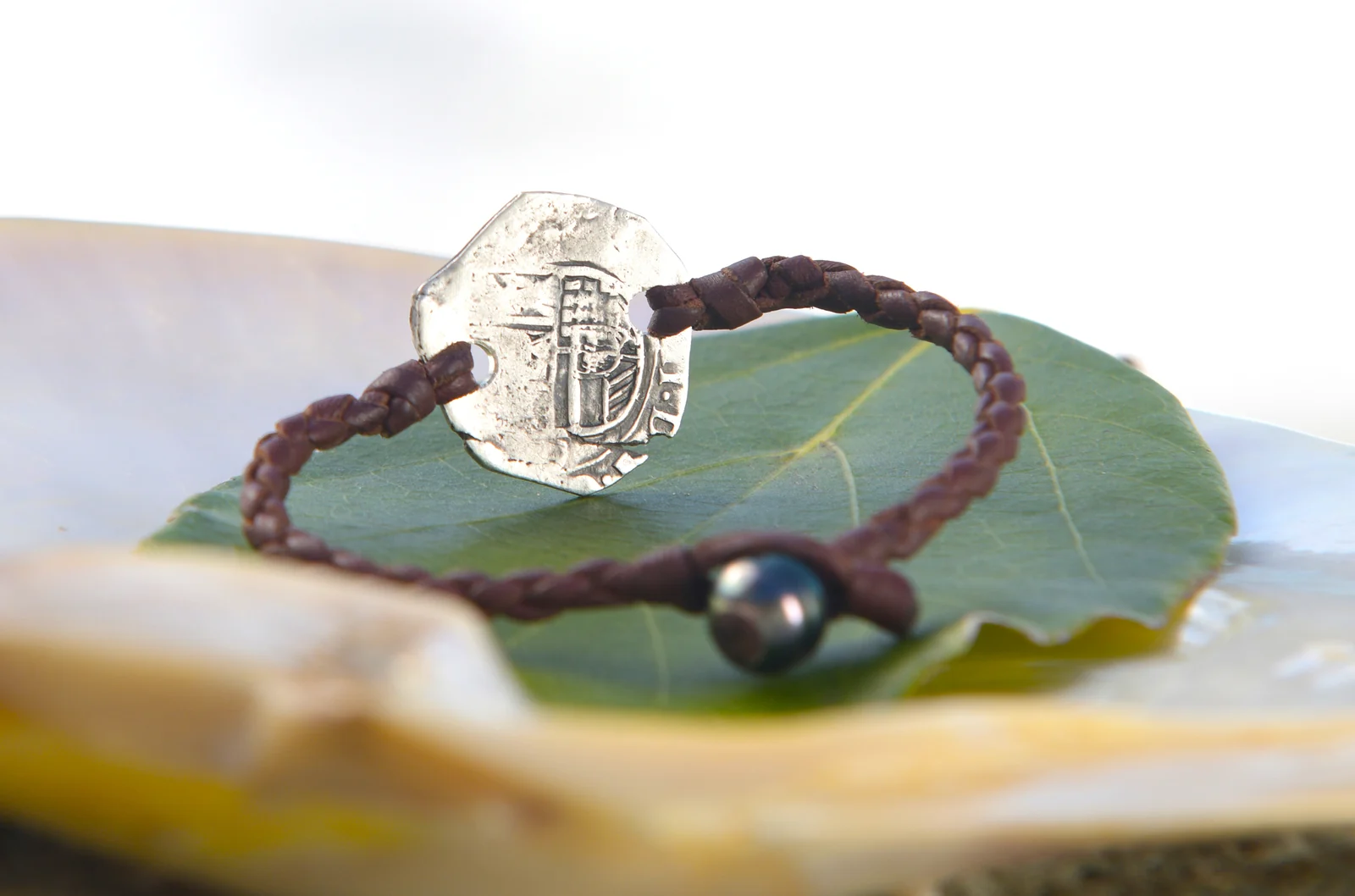 Revers de la monnaie ancienne en argent du bracelet en cuir tressé, présenté sur une feuille