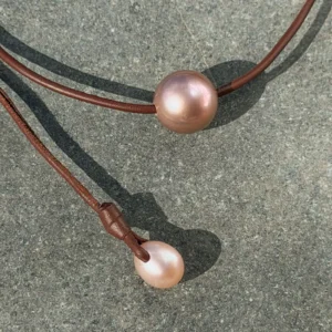 Leather choker with a large 14 mm pink pearl, on a stone, detail.