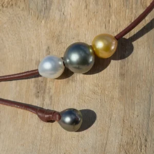Tricolor choker with Tahitian and South Sea pearls, on wood, detail.