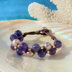 Bracelet double rang, perles roses et améthystes, sur un coquillage.