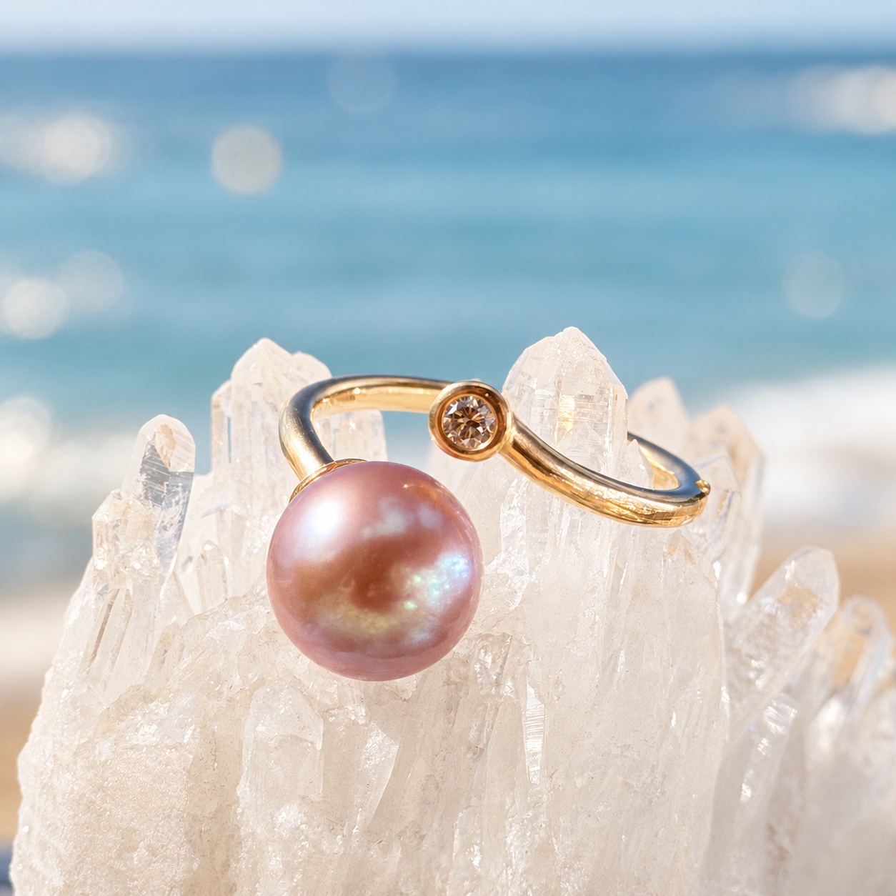 Precious gold ring with a pink pearl and diamond, on a crystalline display.