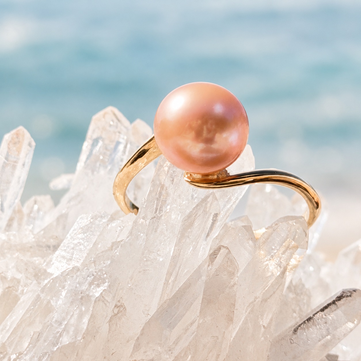 Close-up of the round pearl with pink reflections and the gold setting of the Vague ring.