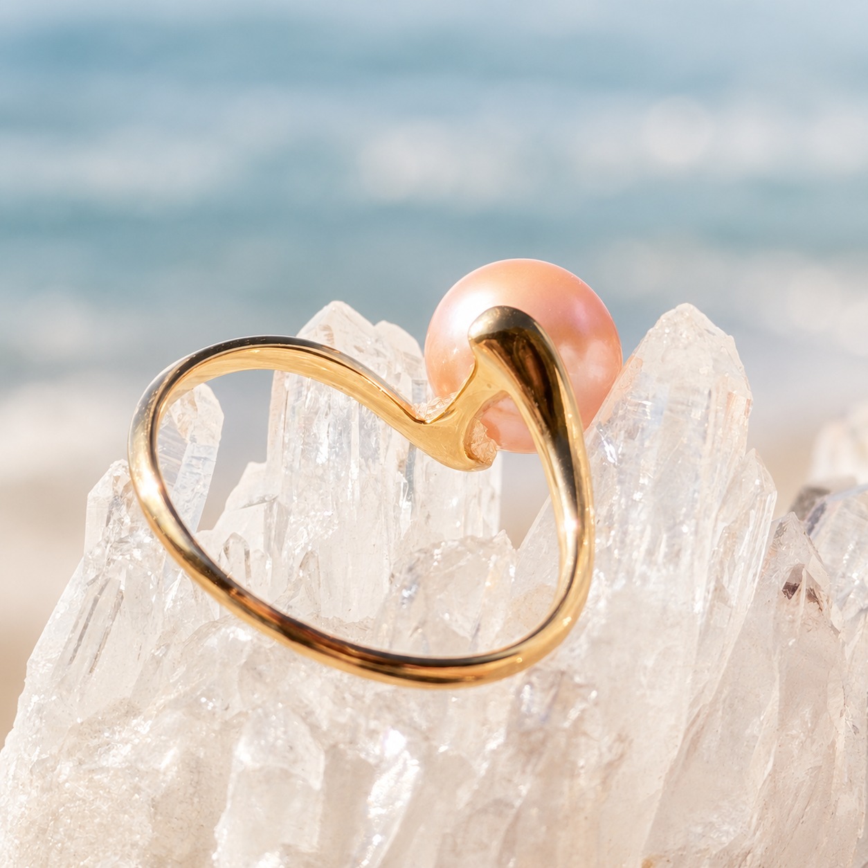 Side view of the Vague ring showing the curves of its gold setting and the back of the pearl.